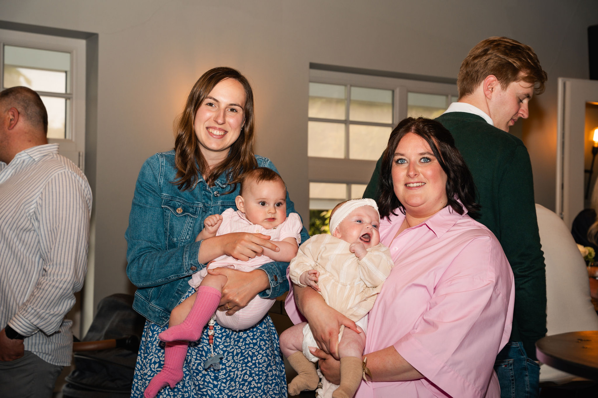 Twee mama's met hun baby's op de arm tijdens de babyborrel