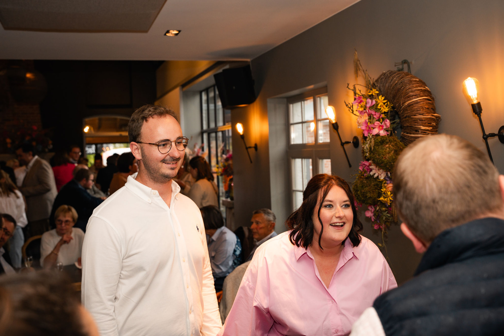 Ouders begroeten lachend hun gasten tijdens de babyborrel