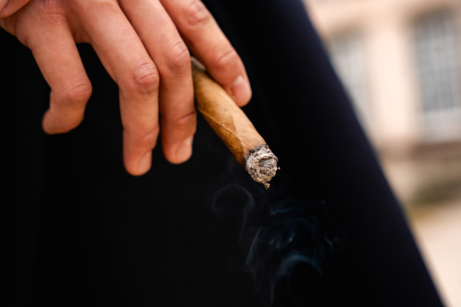 Close-up van een hand met brandende sigaar