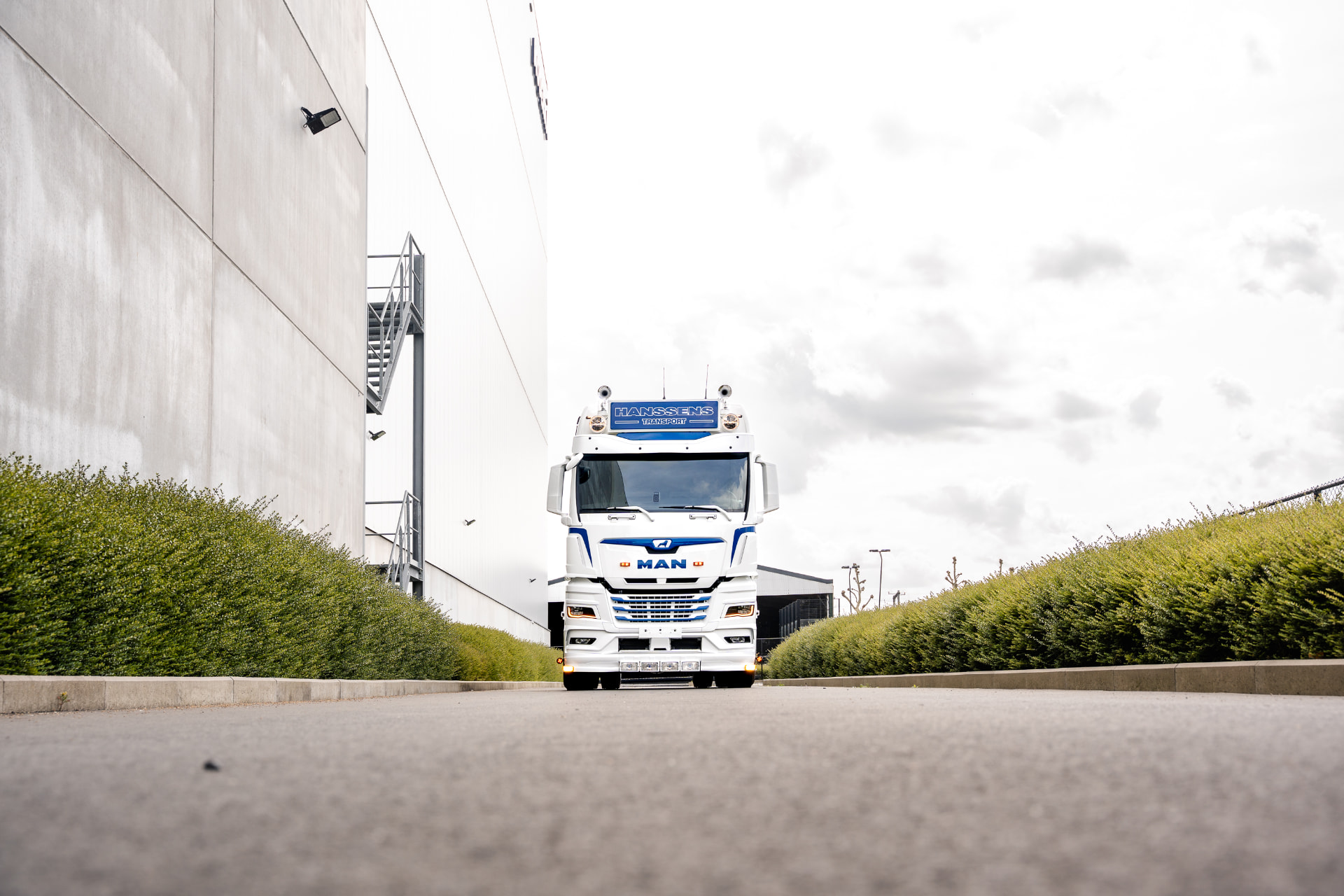 Witte MAN-truck van Hanssens Transport frontaal in een oprit