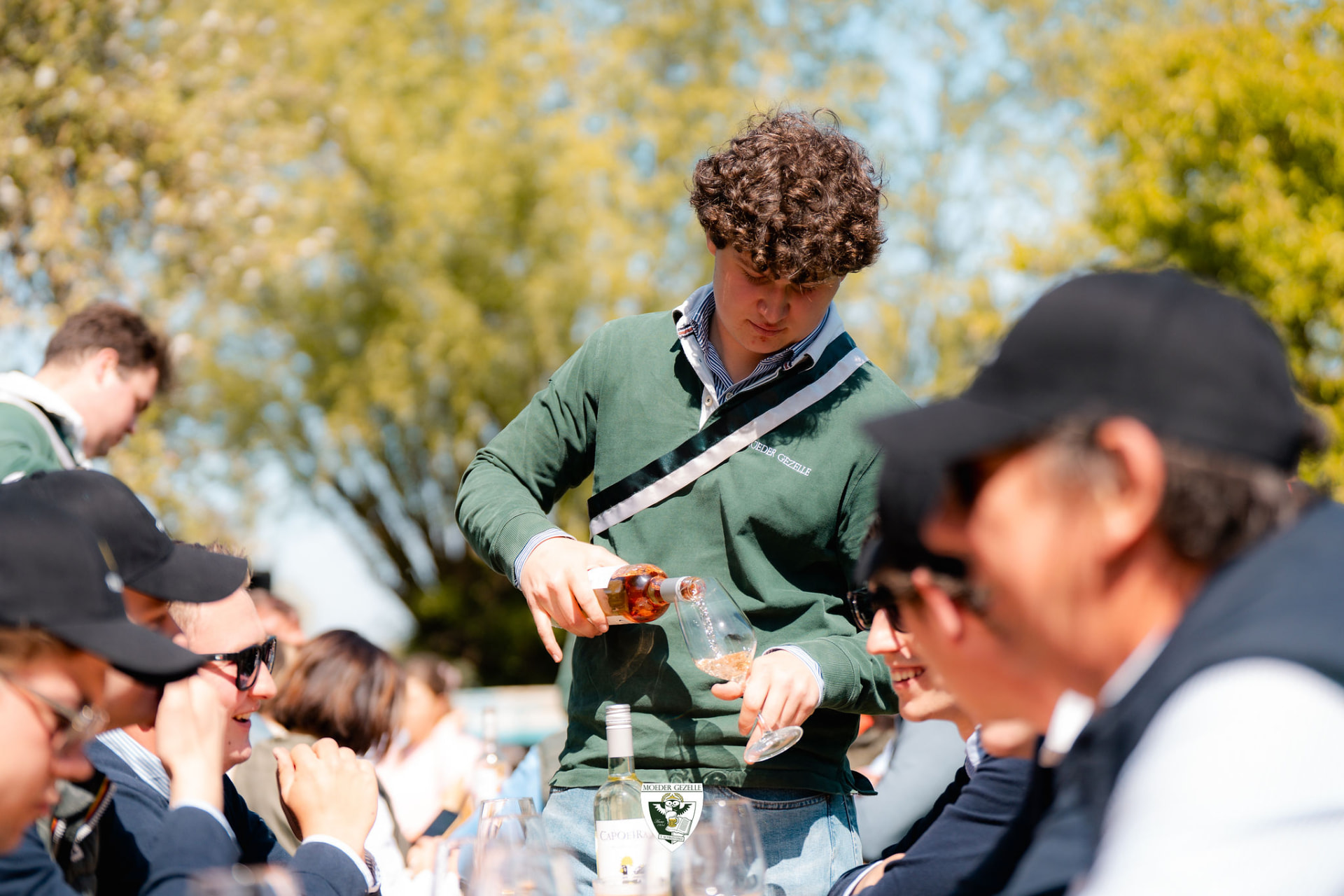 Medewerker schenkt wijn uit voor de gasten aan tafel