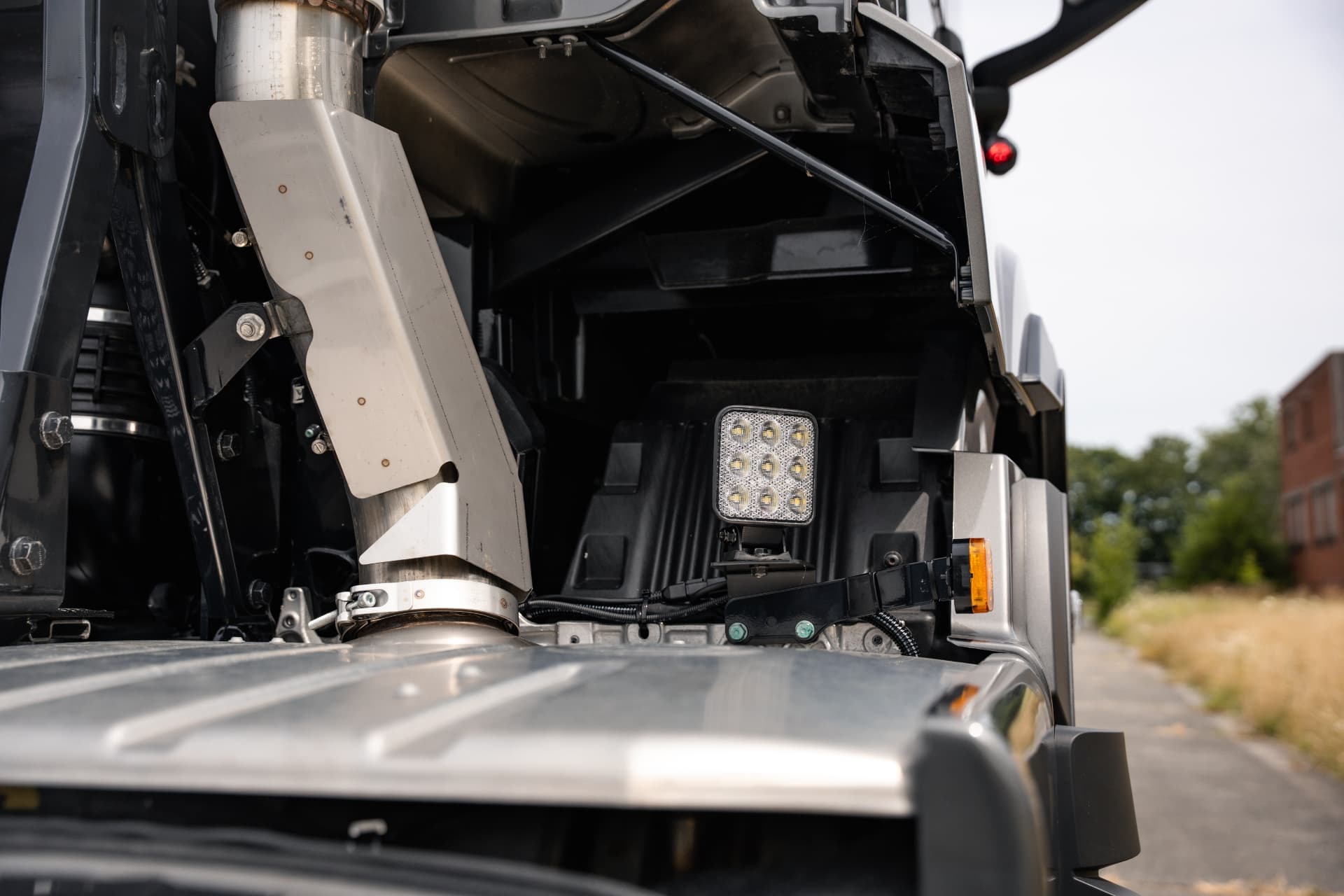 Werklamp achter de cabine tussen uitlaat en chassis