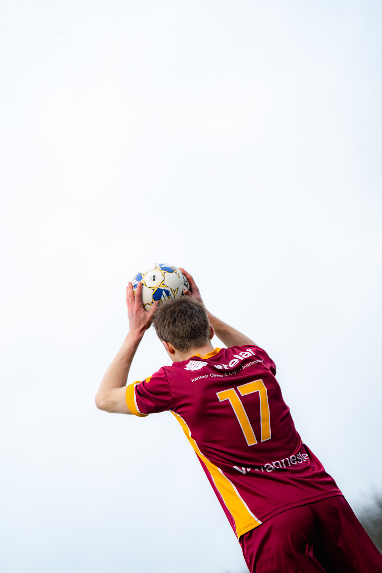 Speler neemt een ingooi tegen de witte lucht