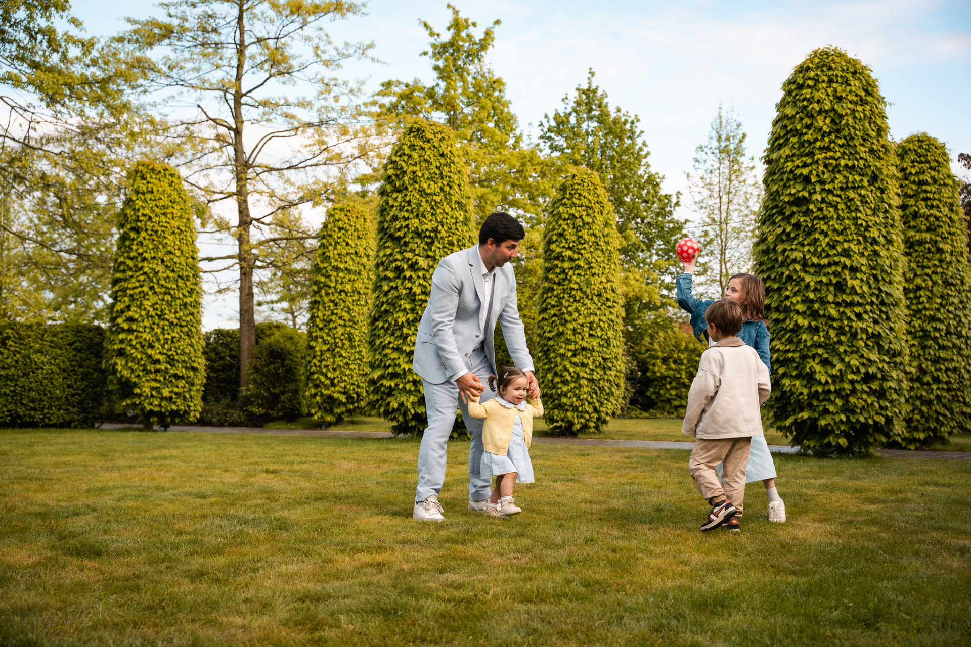 Papa speelt met de kinderen en een bal in de tuin