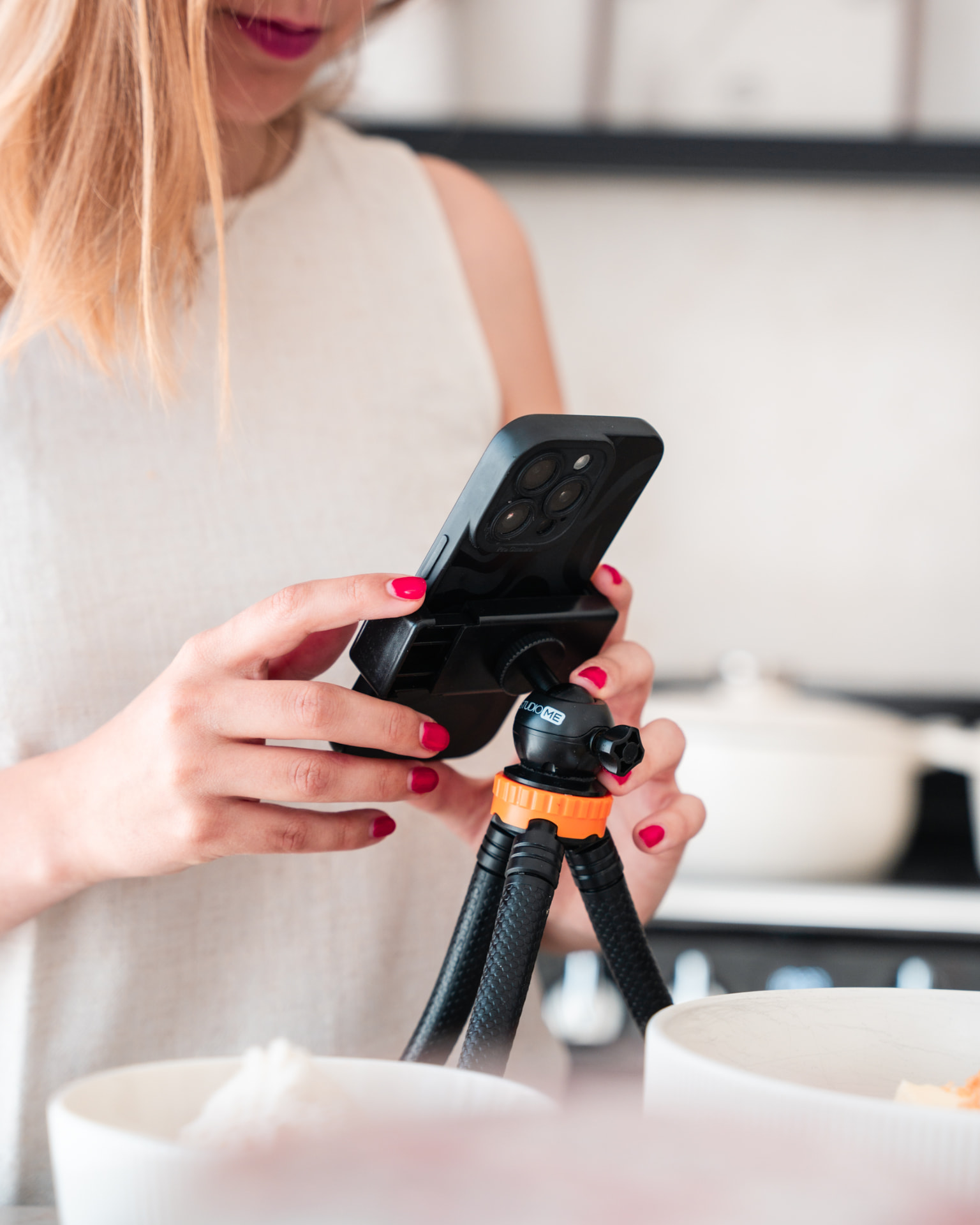 Handen die een telefoon op een statief instellen