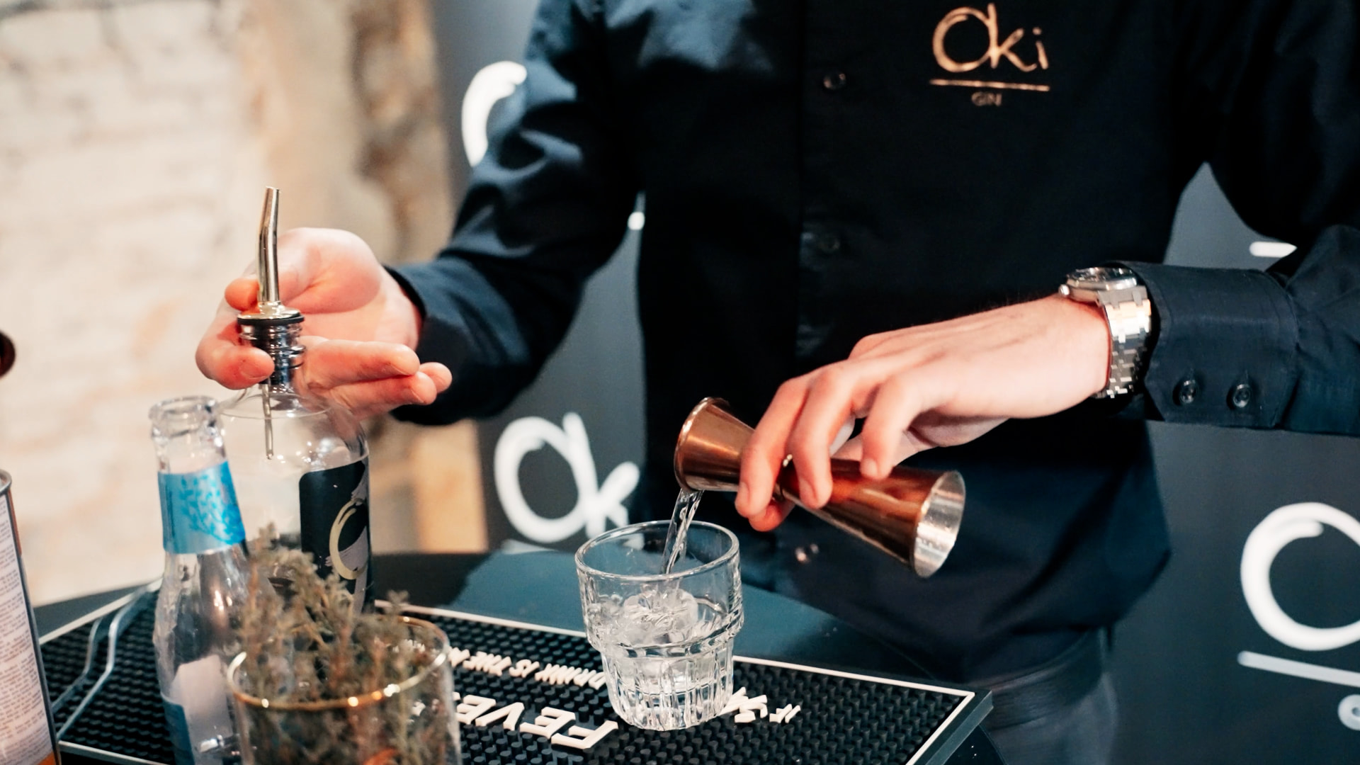 Bartender die gin uitschenkt aan de Oki-bar