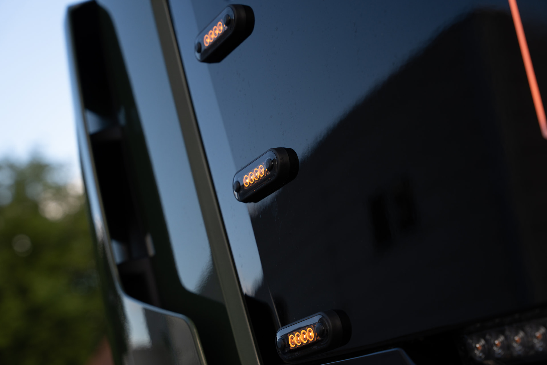 Amberkleurige LED-markeringslampen op een zwarte cabine bij zonsondergang