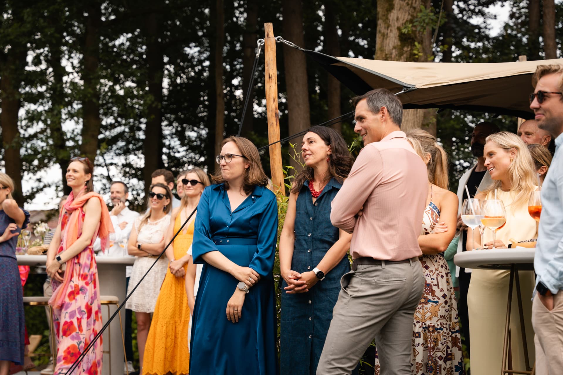Gasten luisteren naar de speech onder de tent