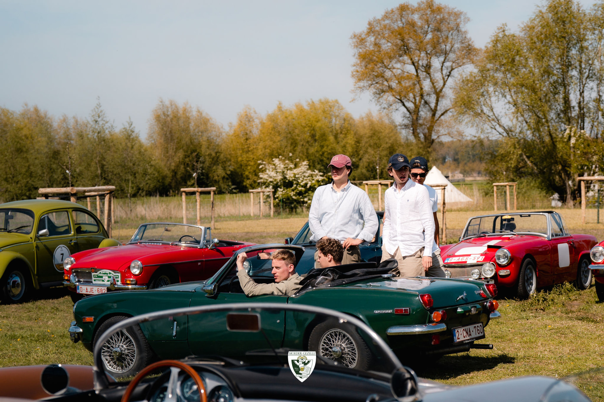 Jonge deelnemers bij een groene Triumph Spitfire