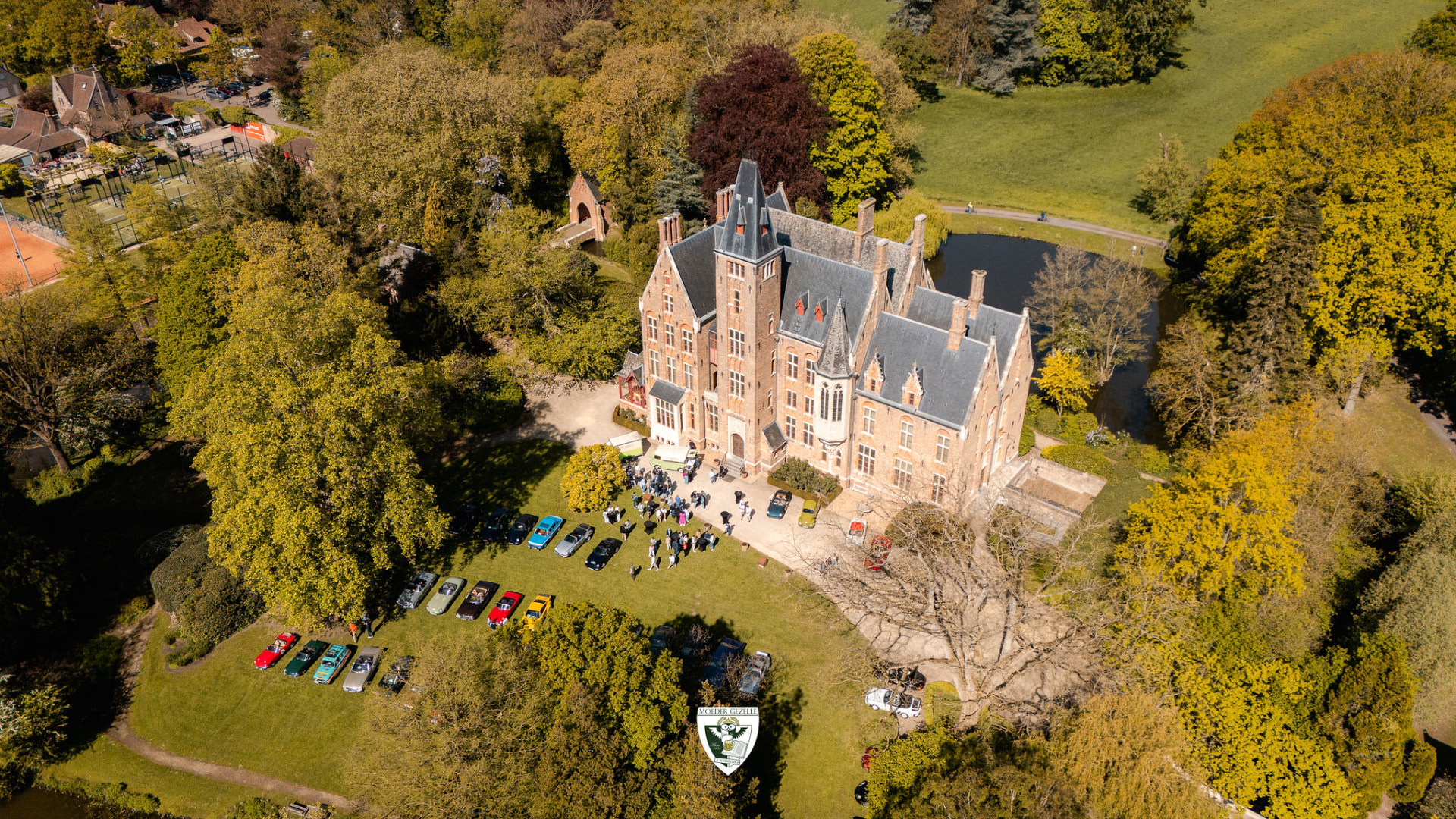 Luchtbeeld van het kasteel van Loppem met oldtimers op het gras