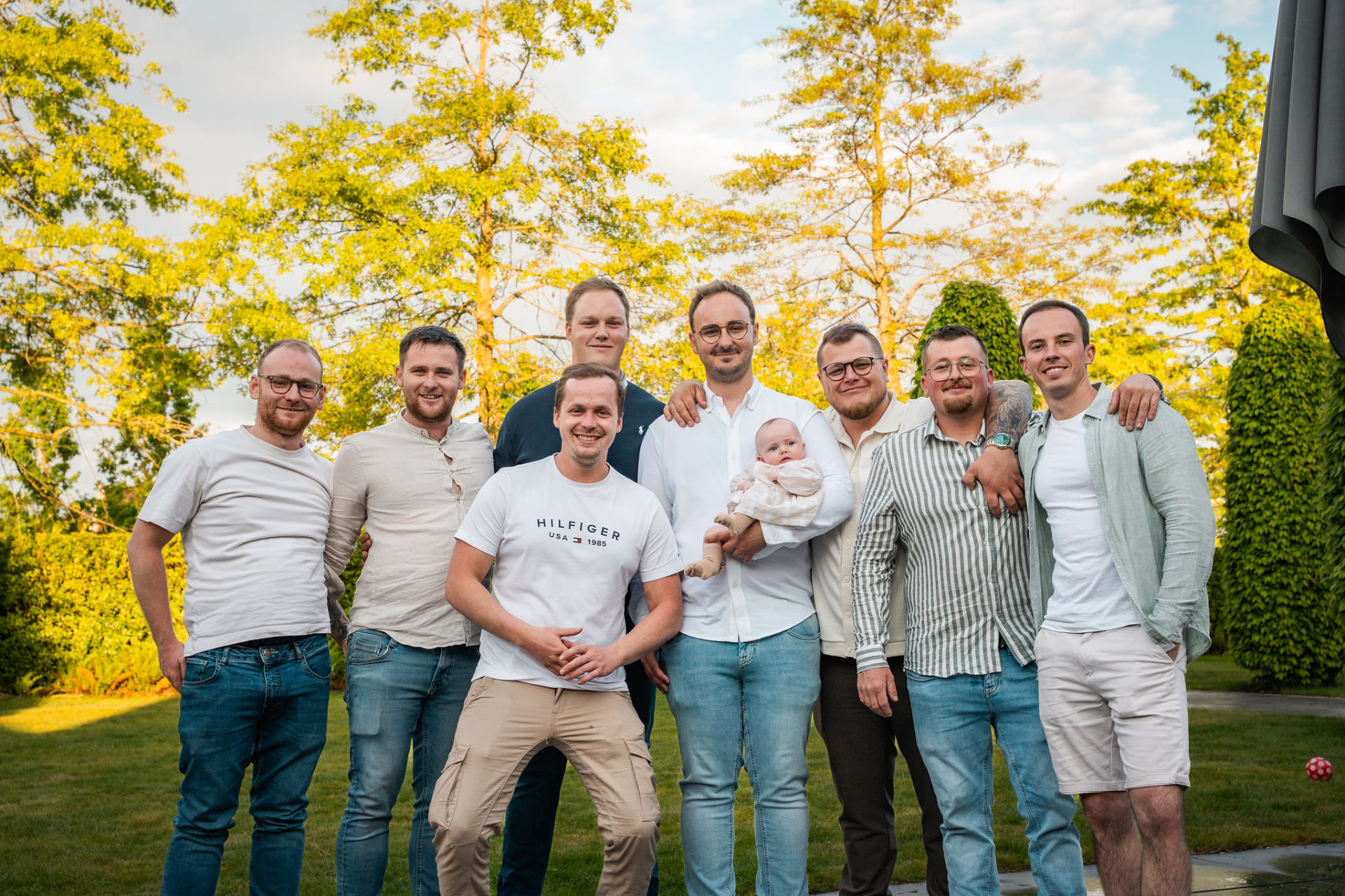 Groepsfoto van de vrienden met papa en de baby