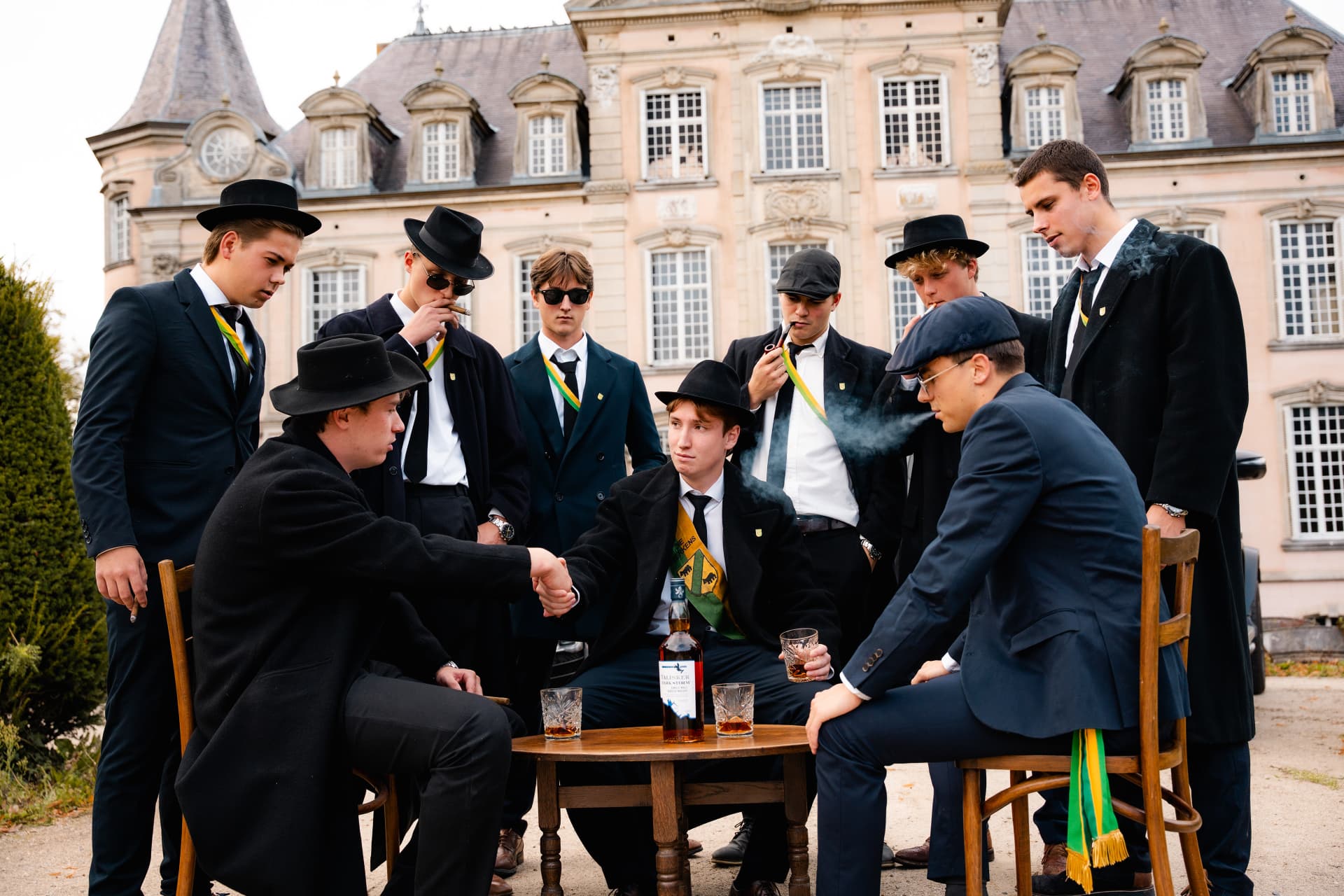 Clubleden rond een tafel met whisky voor het kasteel