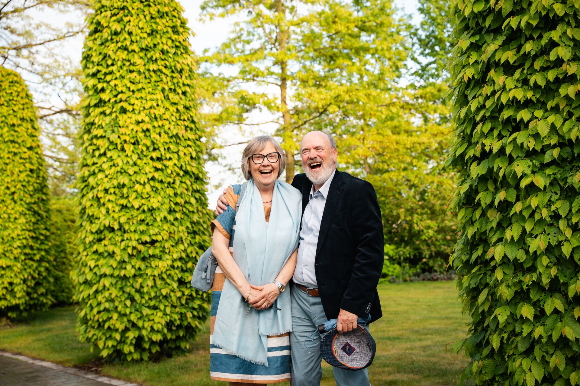 Lachend grootouderkoppel tussen de groene bomen