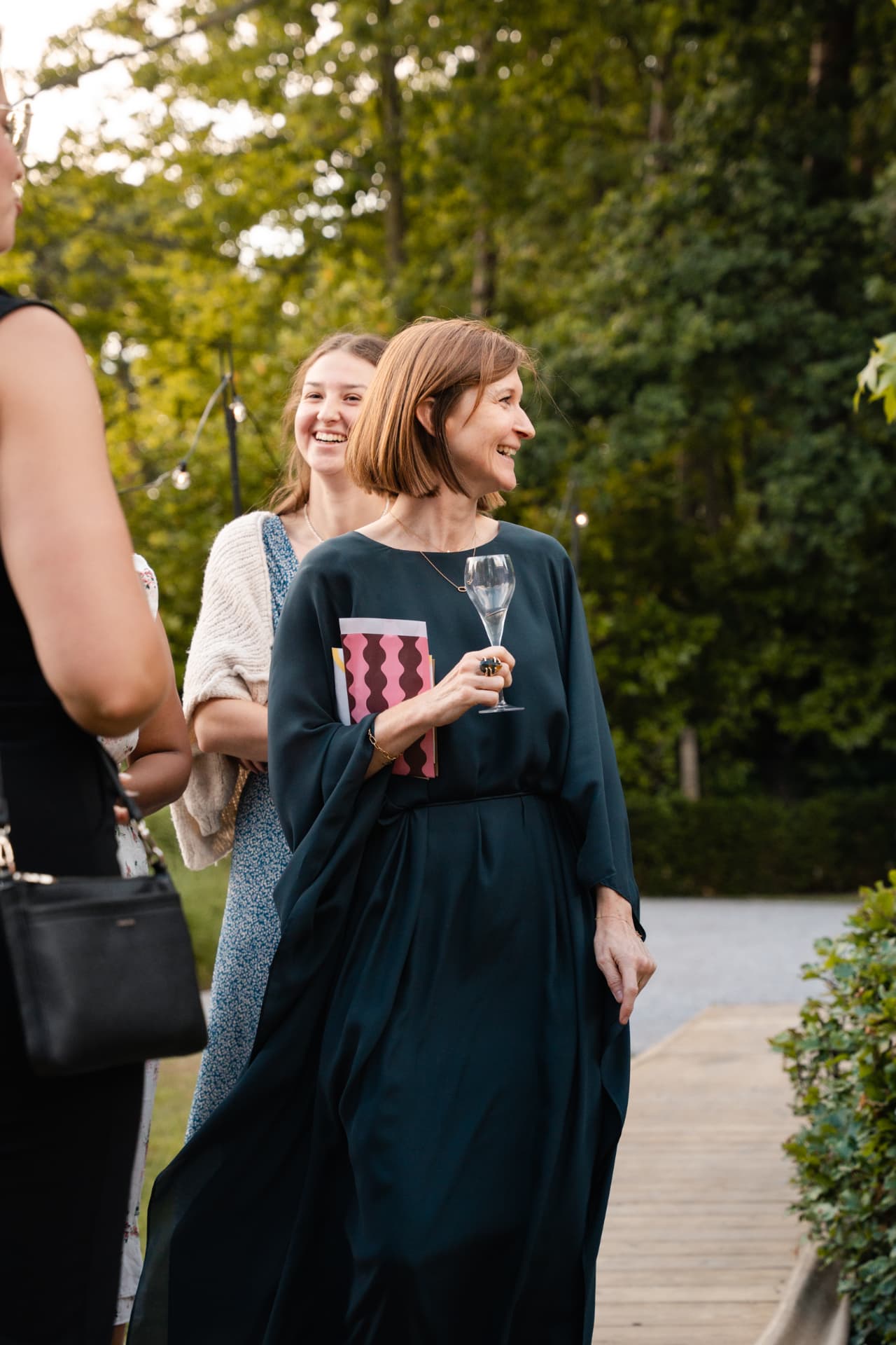 Lachende gasten met champagne op het tuinpad