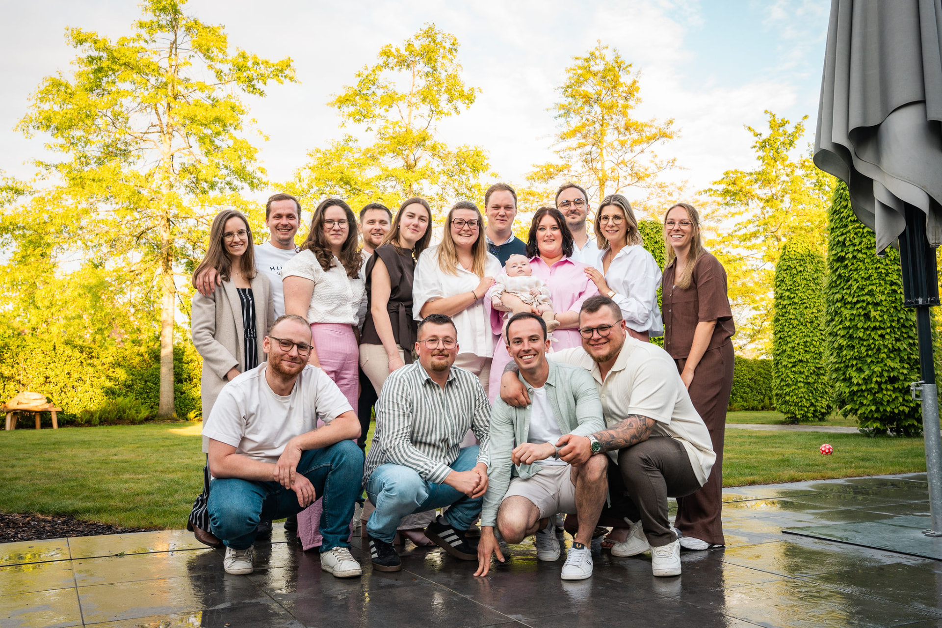 Groepsfoto van alle vrienden met de baby op het terras