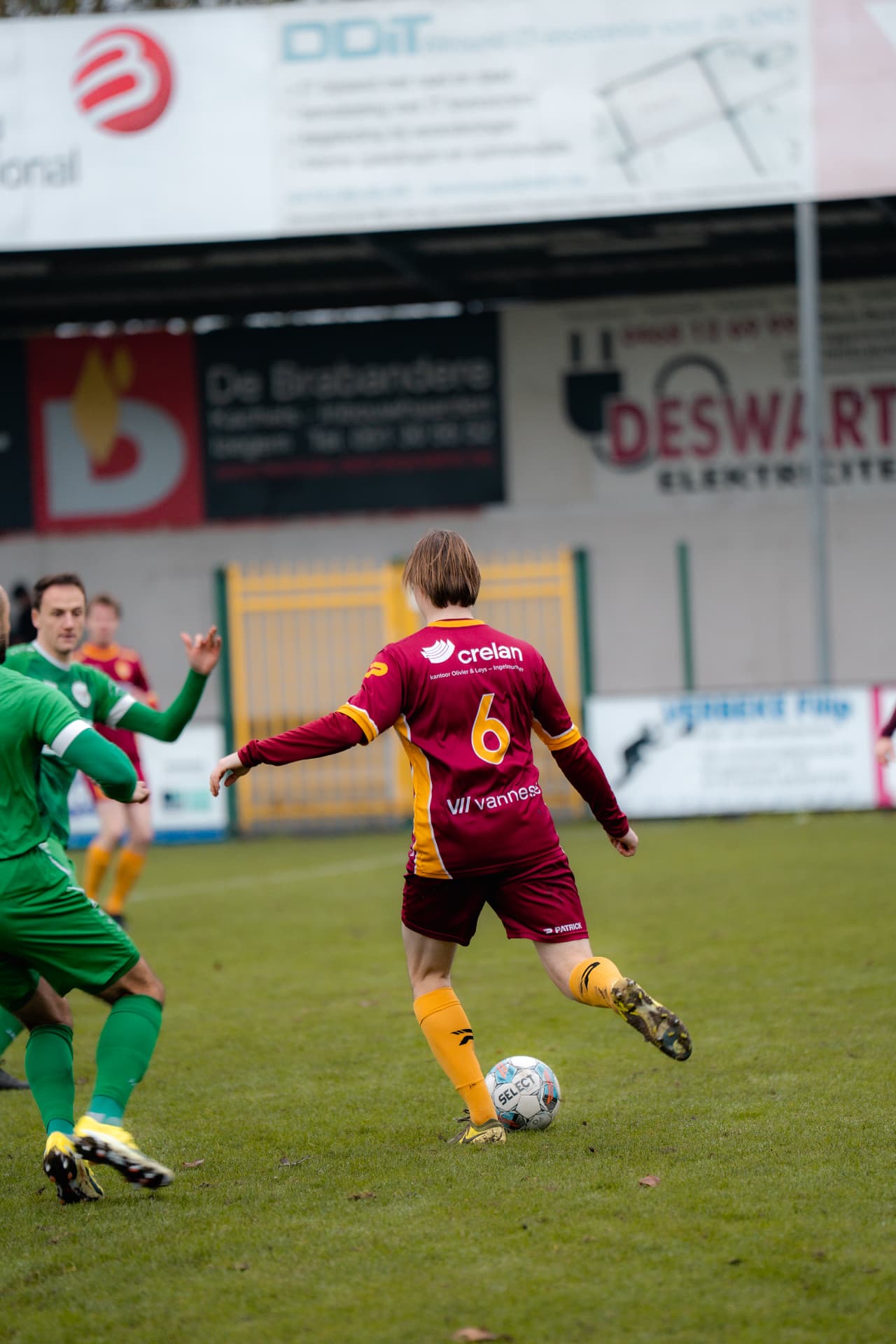 Speler met rugnummer 6 trapt de bal weg