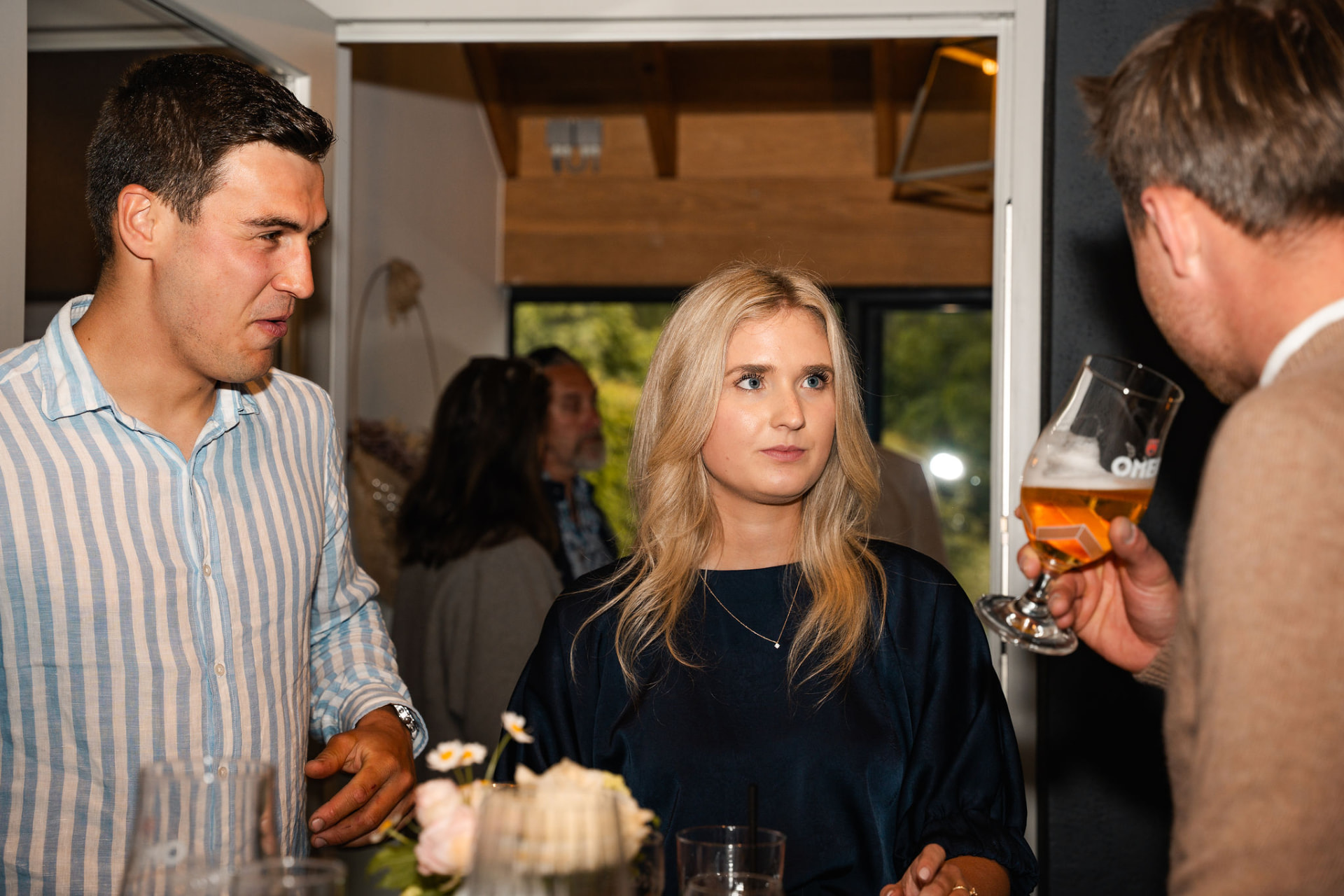 Gasten praten met een glas in de hand tijdens de babyborrel