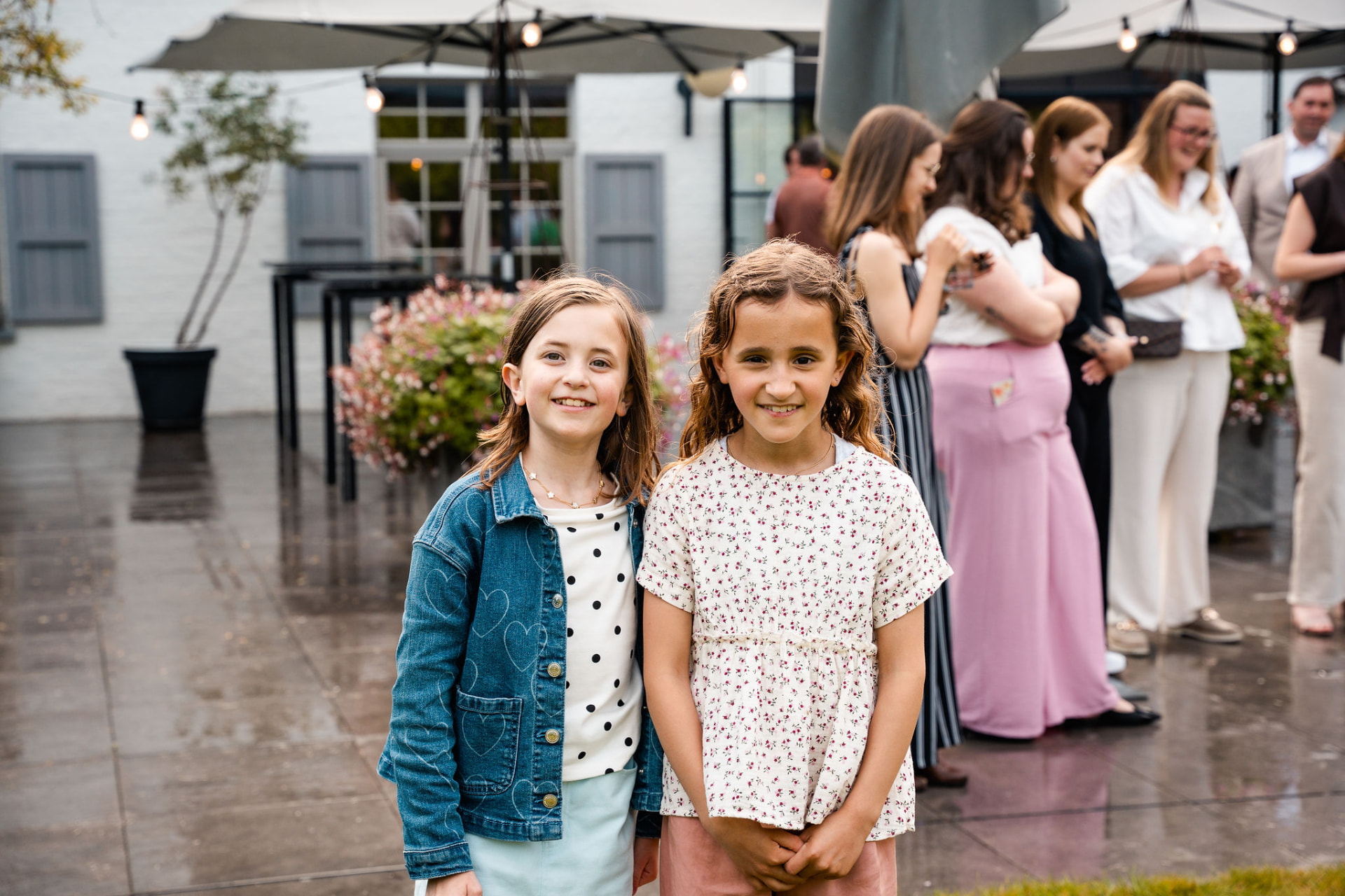 Twee meisjes lachend naar de camera op het terras