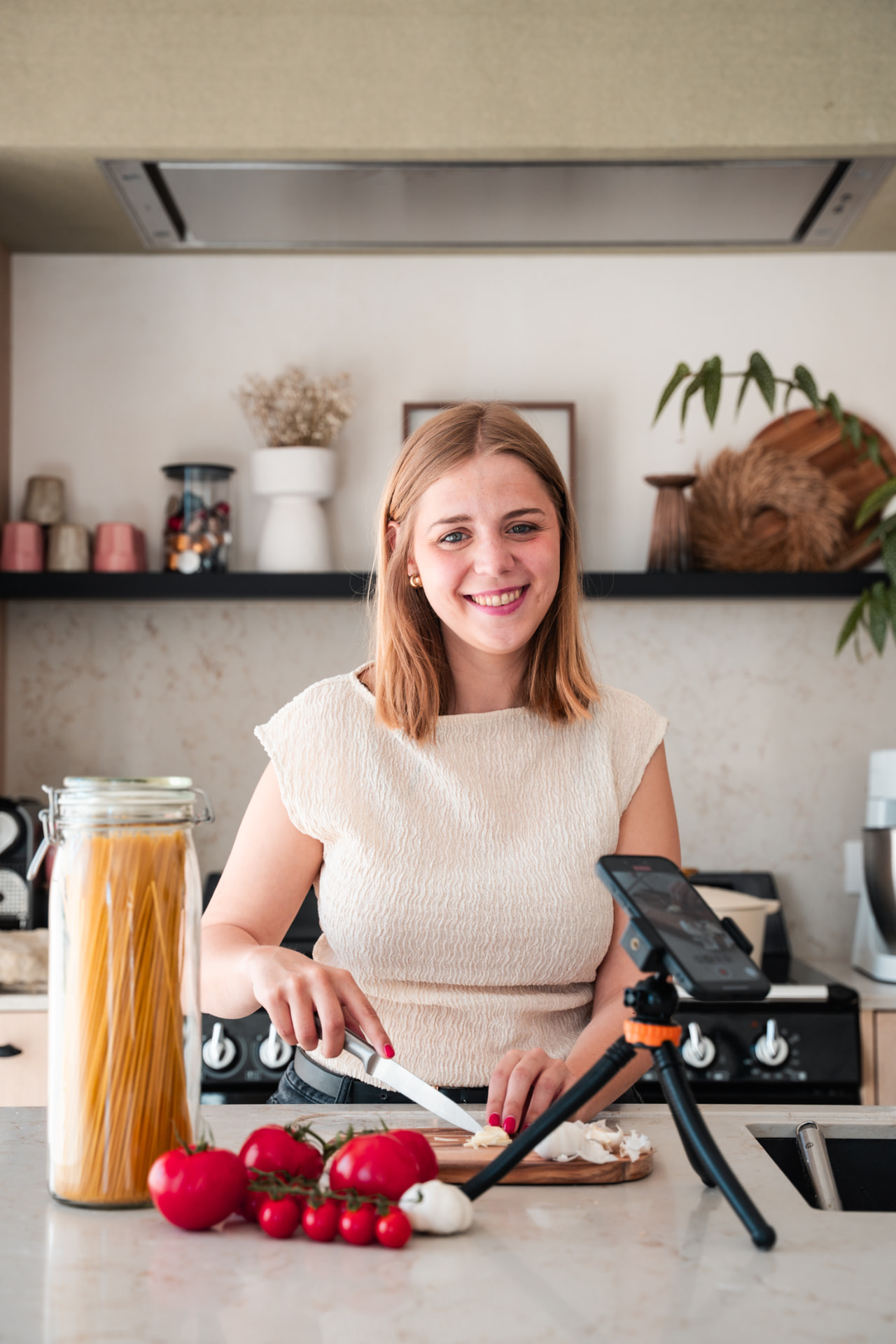 Vrouw die groenten snijdt terwijl haar telefoon filmt