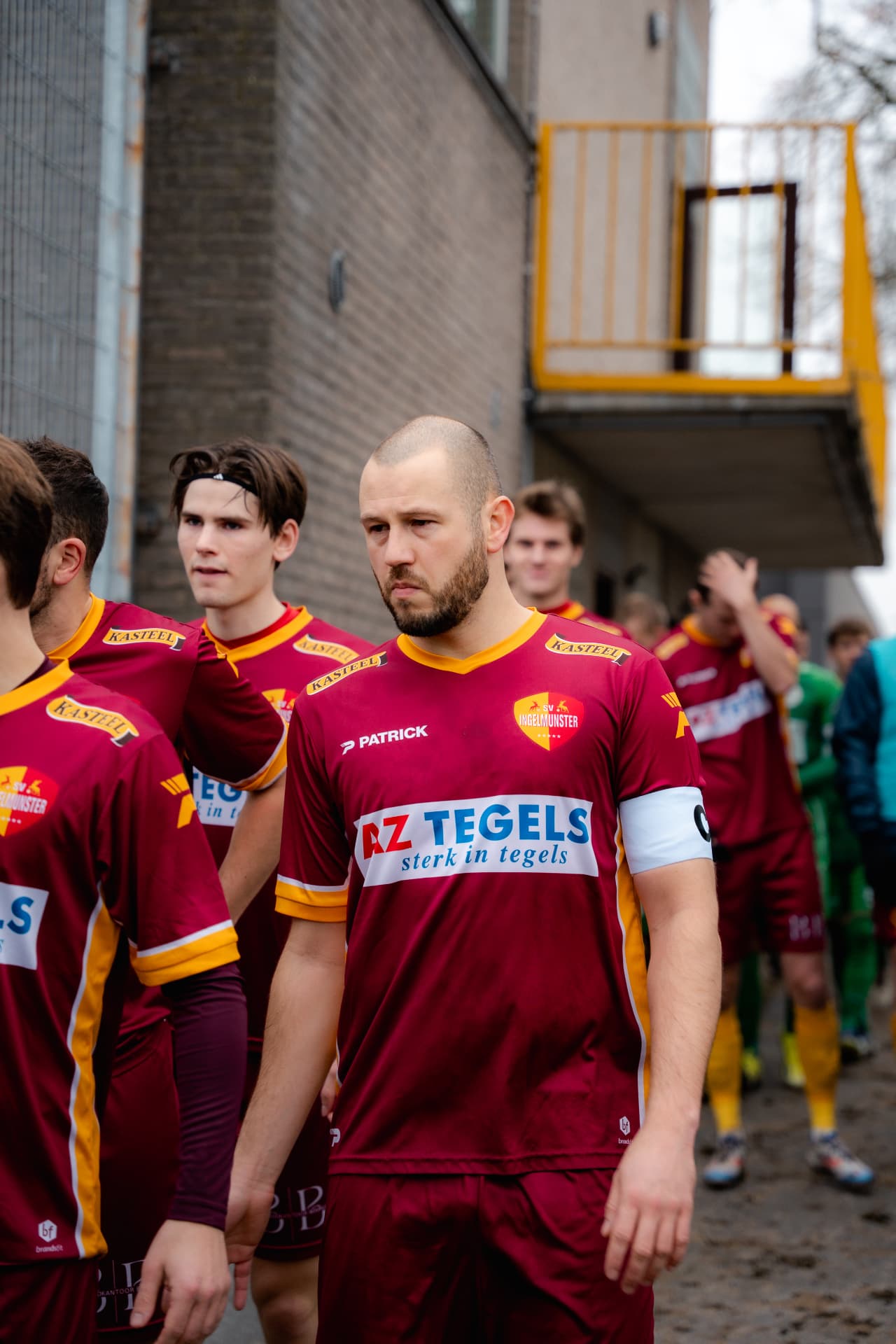 Spelers van SV Ingelmunster stappen het veld op, aanvoerder op kop