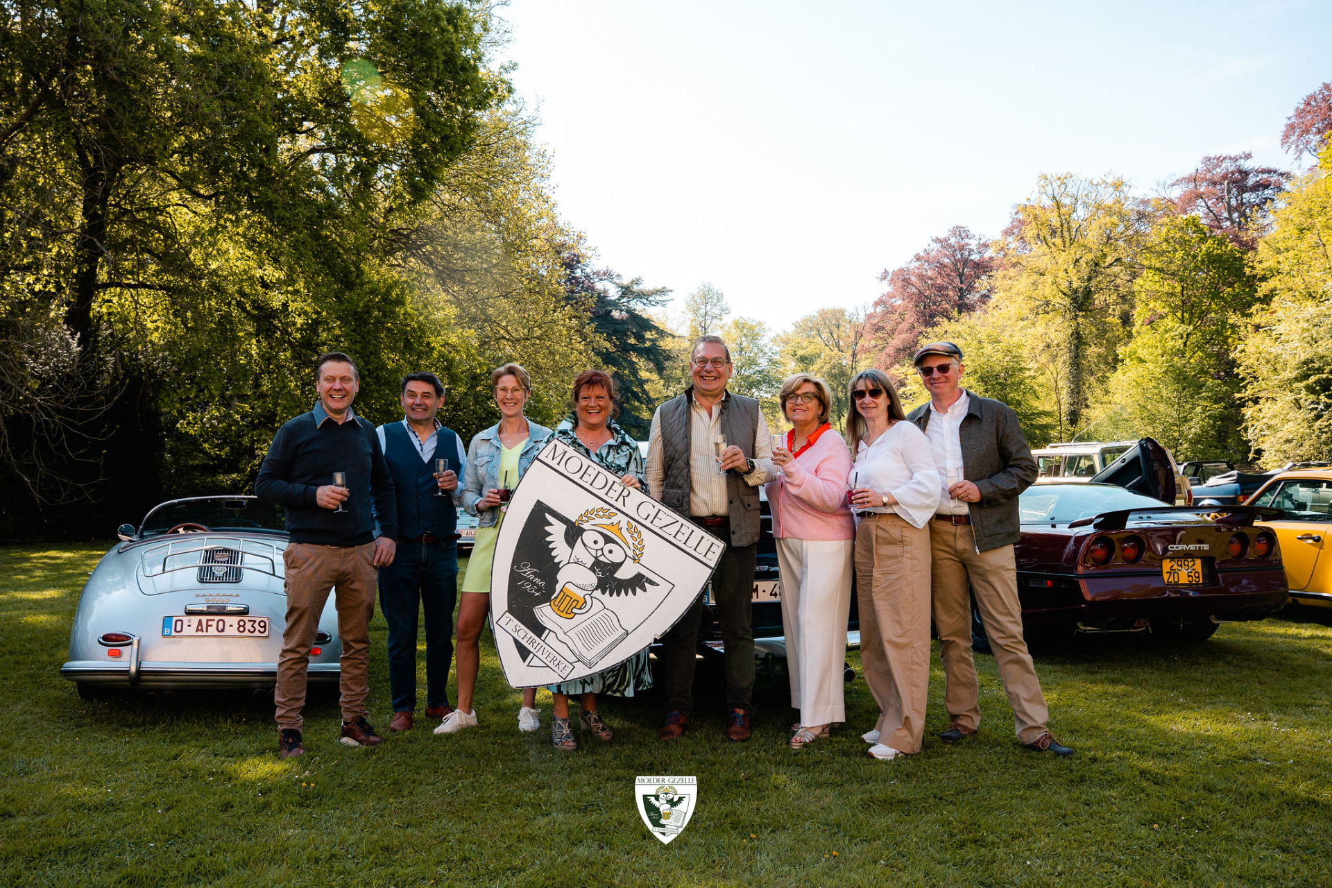 Groepsfoto met het Moeder Gezelle-schild tussen de oldtimers