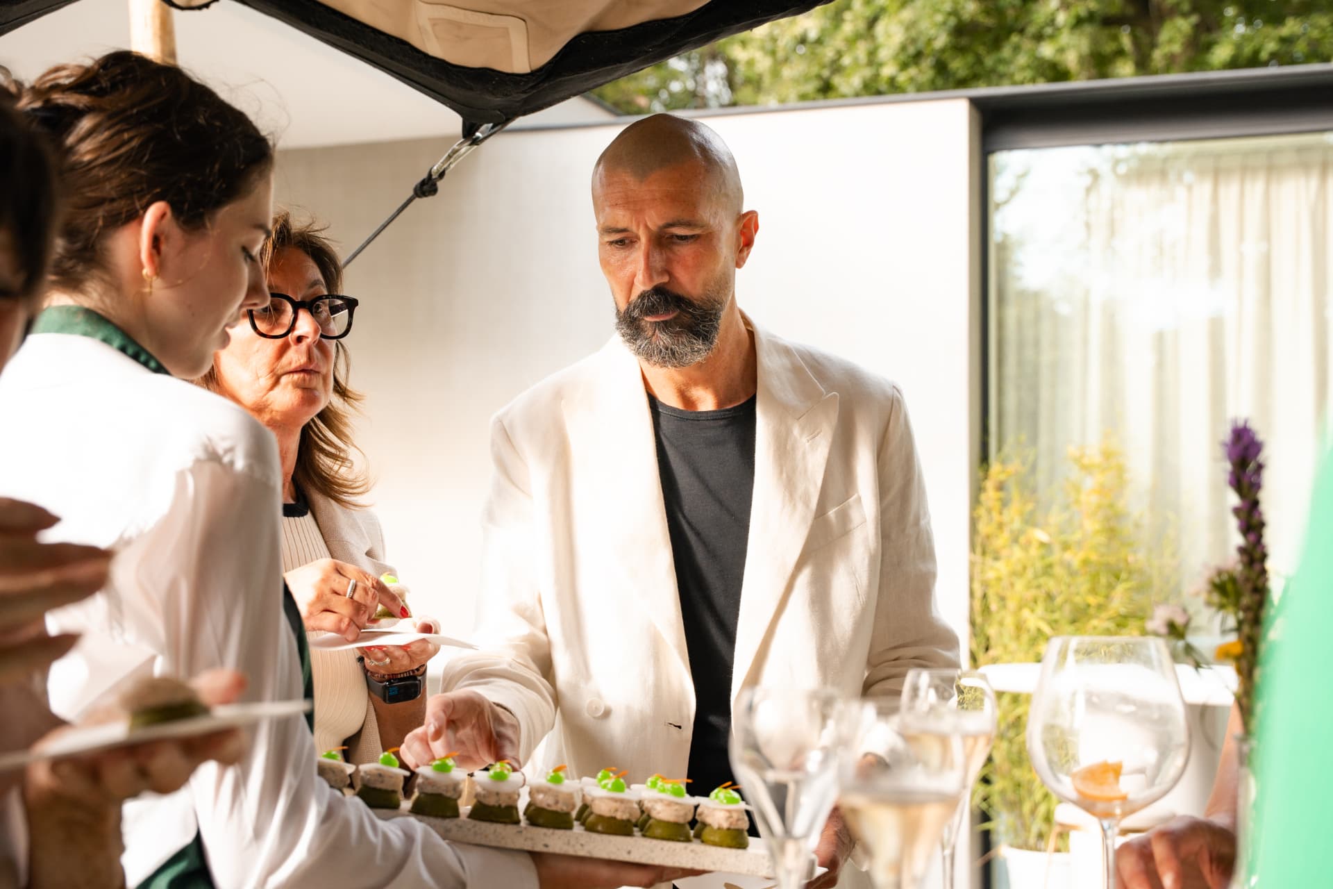 Gast neemt een hapje van het plateau onder de tent