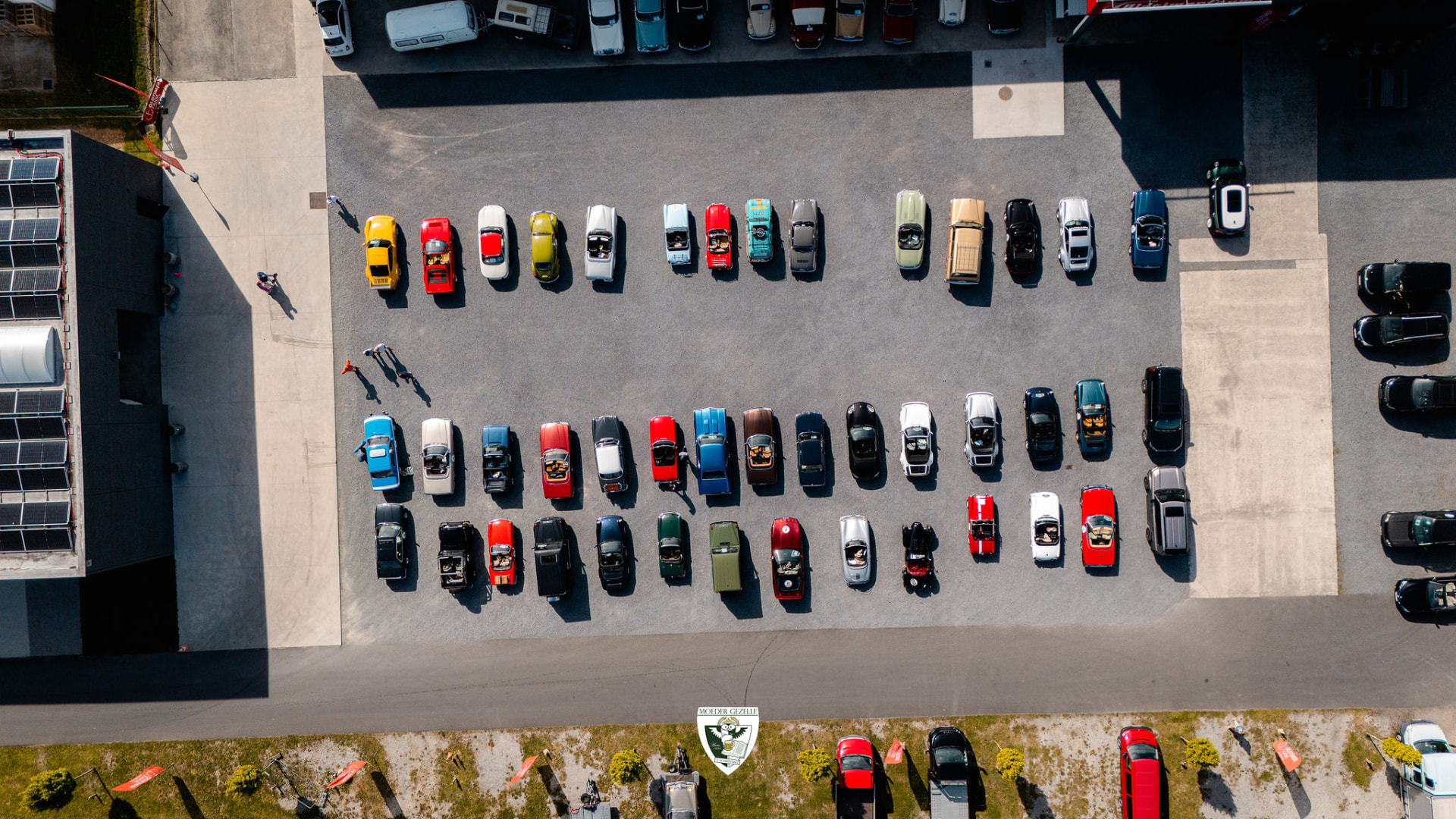 Luchtbeeld recht boven twee rijen kleurrijke oldtimers op de parking