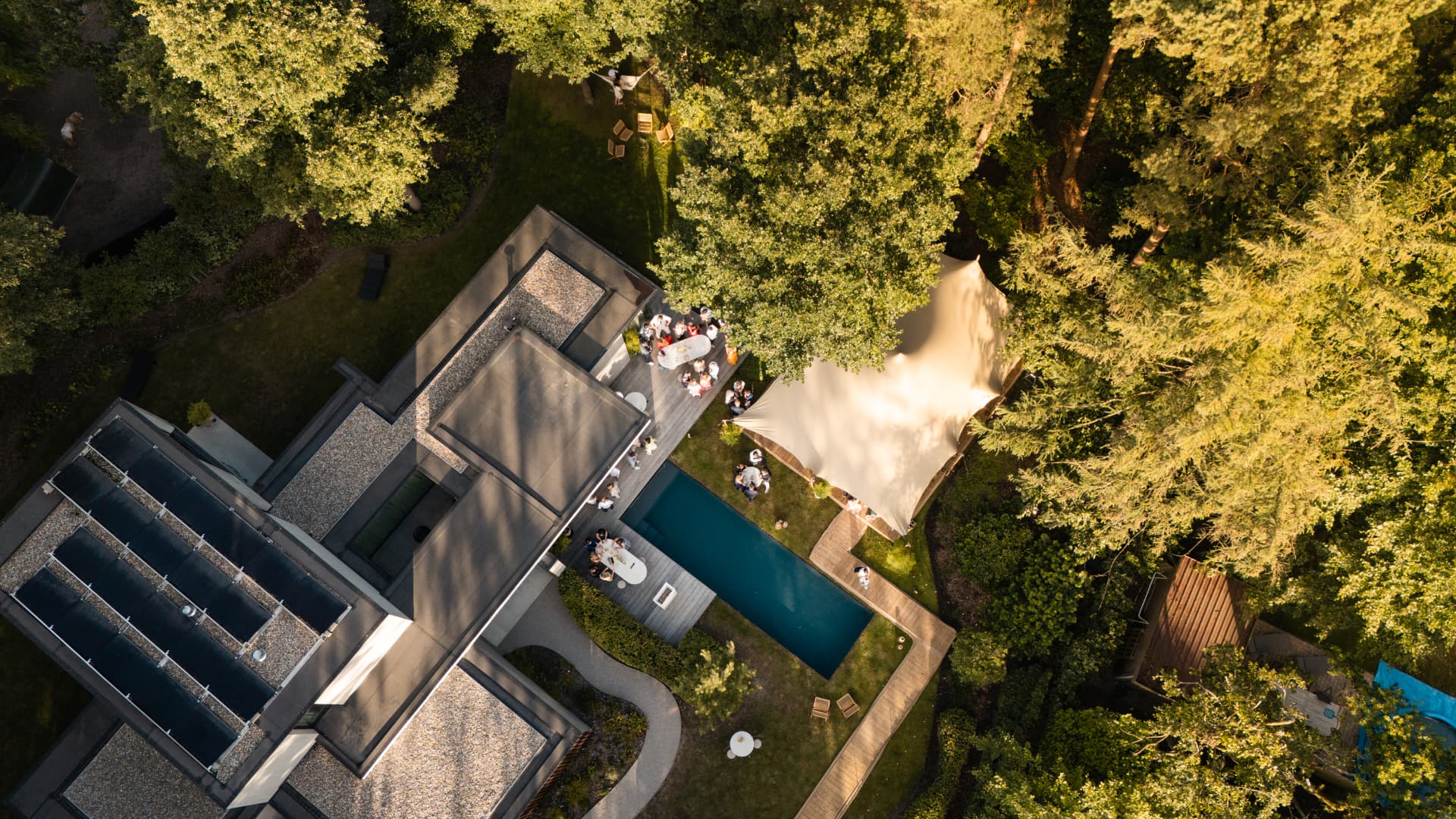 Dronebeeld recht boven het huis met zwembad en stretchtent