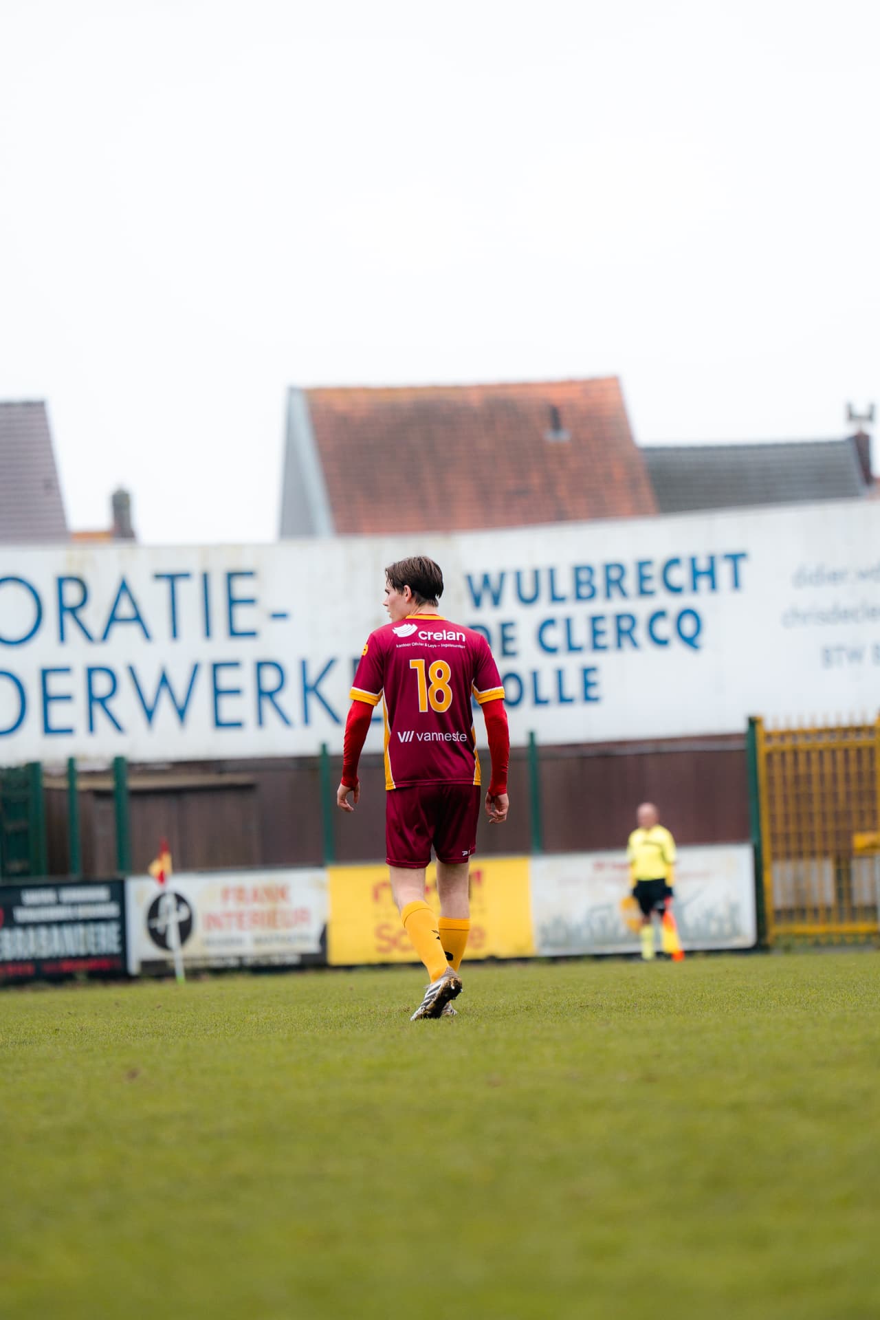 Speler met rugnummer 18 alleen op het veld voor de reclameborden