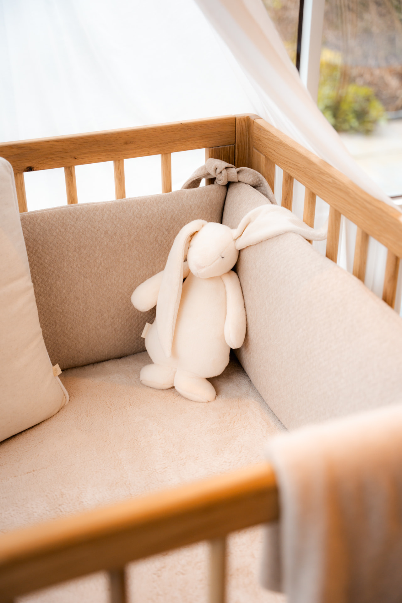 Zachte knuffelhaas in een babybed met beige bedomranding