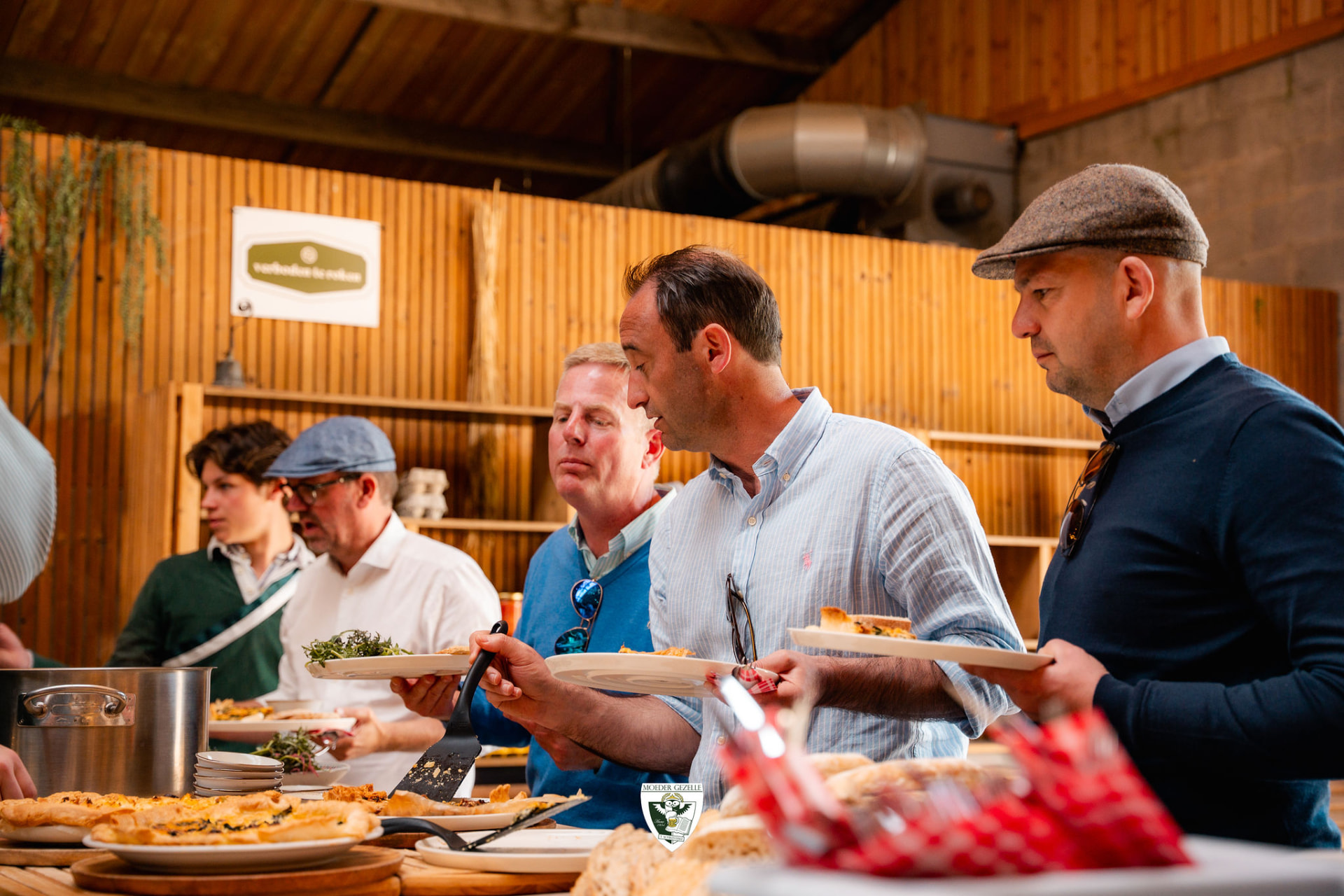 Gasten scheppen hun bord vol aan het buffet in de schuur