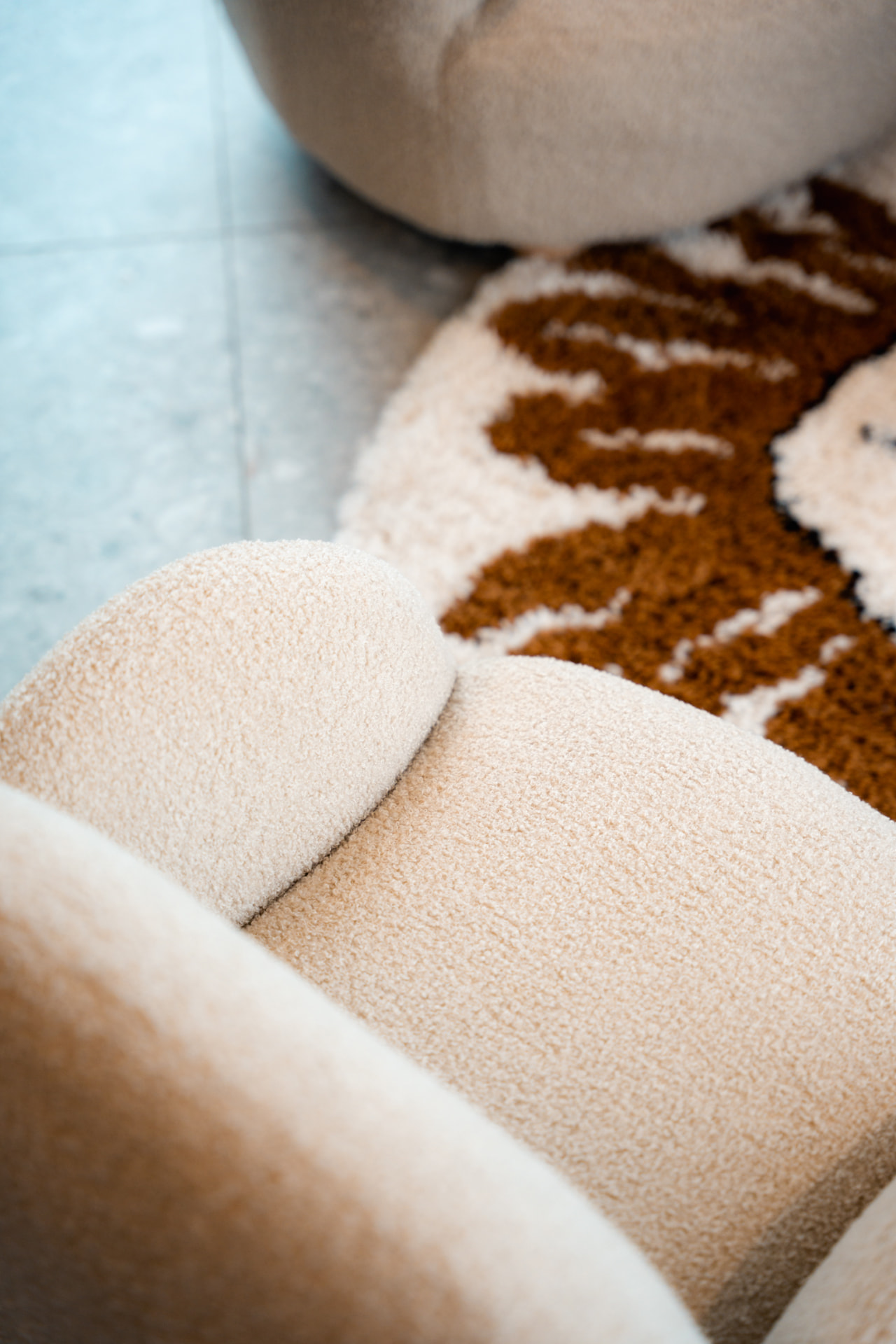 Detail van bouclé stof van een kinderfauteuil op een tapijt