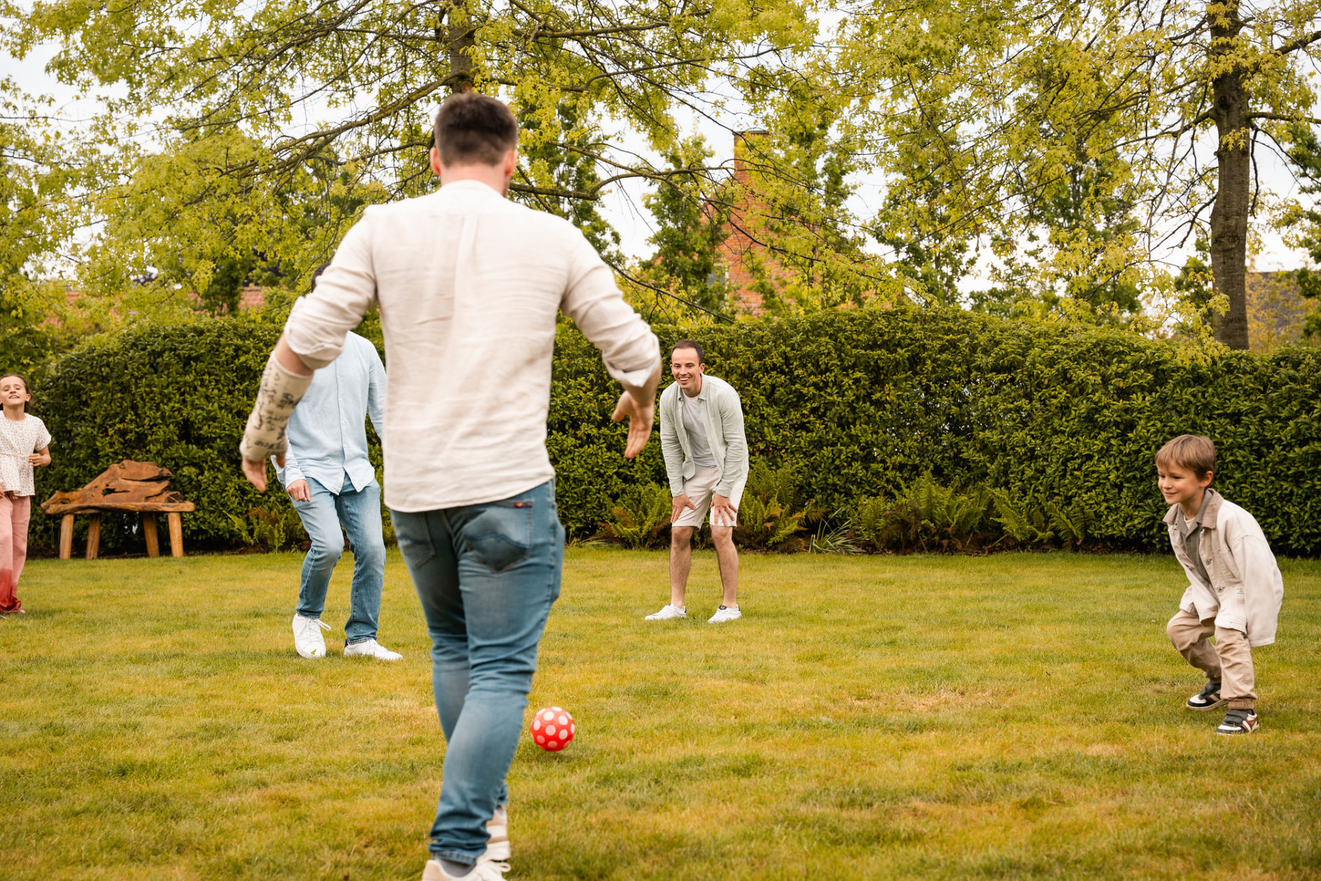 Kinderen en gasten spelen bal op het gras achter de feestzaal