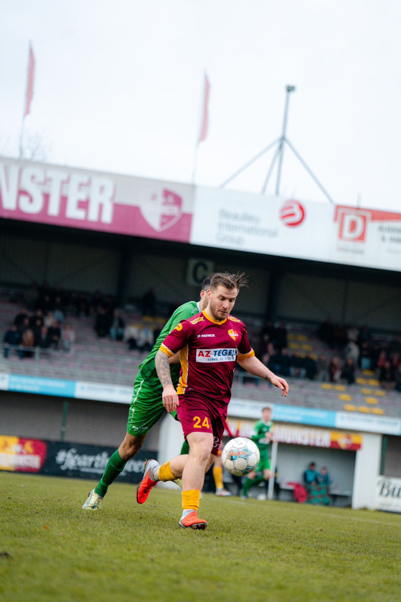 Speler met rugnummer 24 schermt de bal af van zijn tegenstander